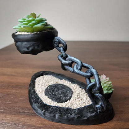 Vaso decorativo fluttuante con succulenta e struttura a catena su base scura