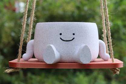 Vaso sospeso sorridente con base in legno appeso all’esterno