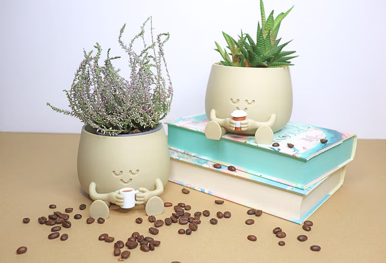 Vaso moderno color crema con personaggio sorridente e pianta decorativa